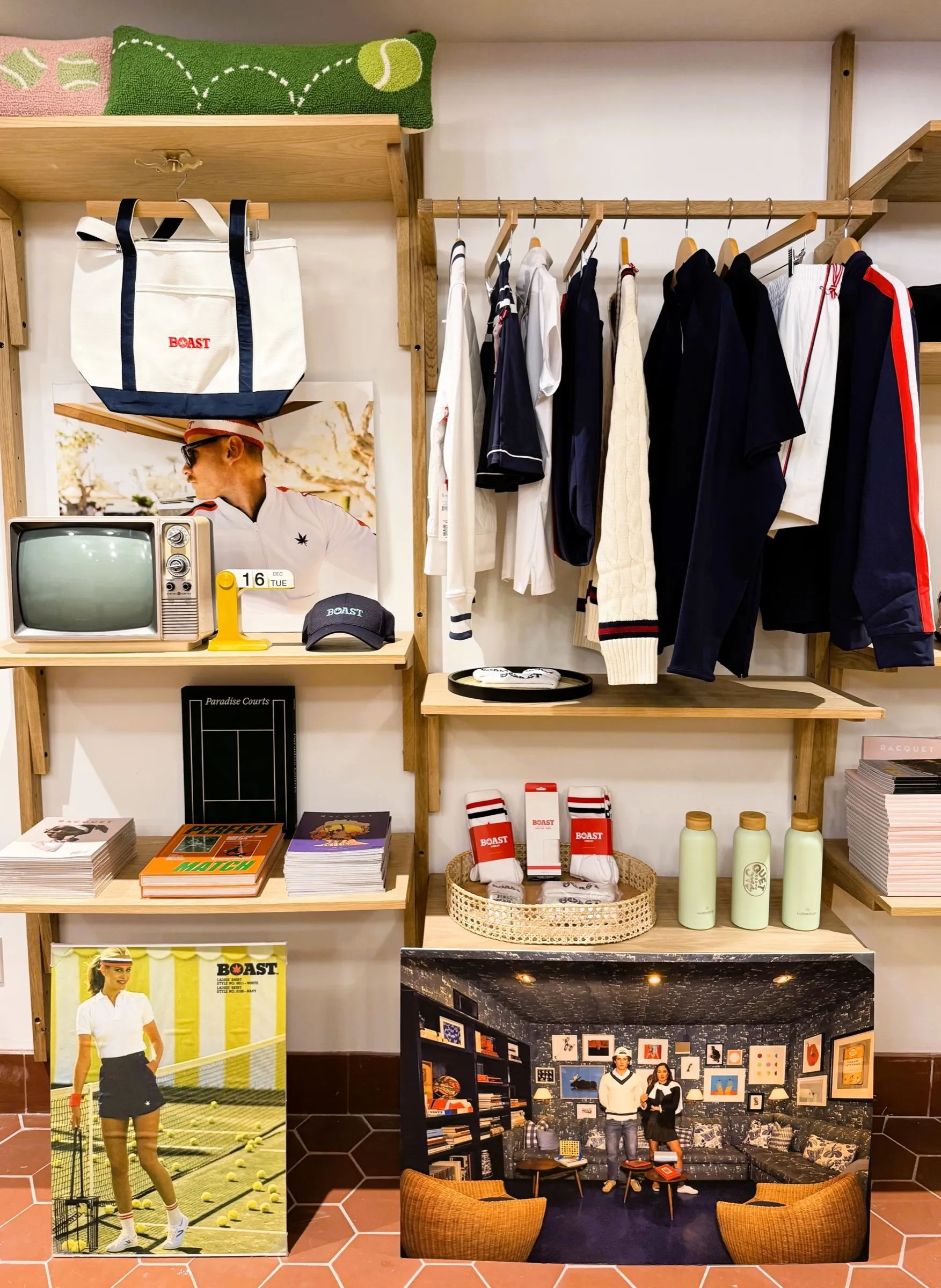 A merchandised wall of BOAST apparel and curated tennis goods in the shop