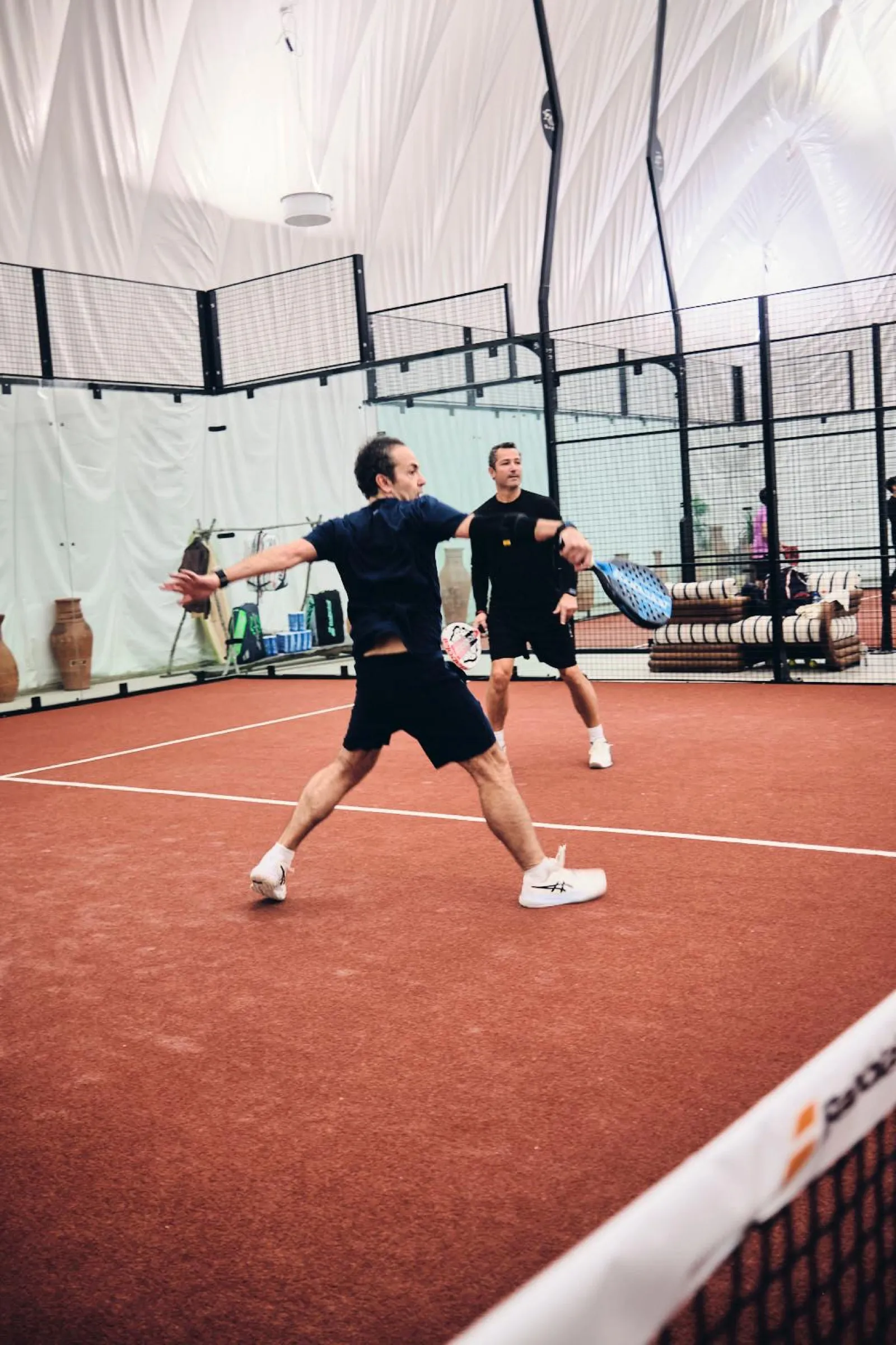 Two players rallying on the padel court at CityView Racquet Club
