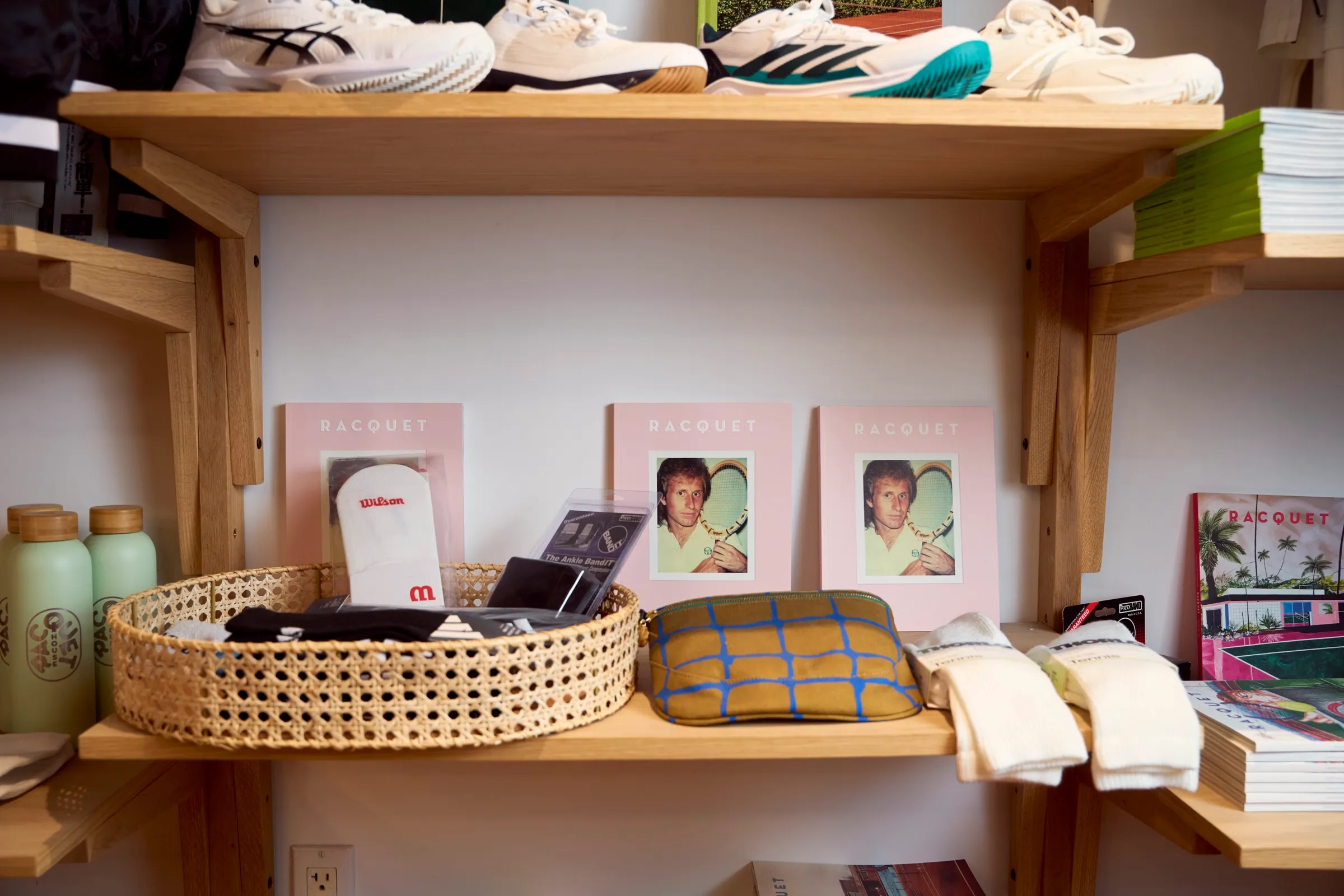 A shelf of tennis shoes and Racquet books in the shop